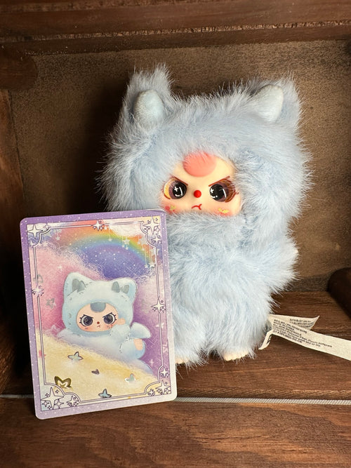 Front view of pale-blue Splashy dragon plush beside character card