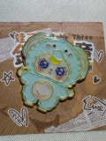 Baby Three Elephant enamel pin in light blue with large ears and a raised trunk on backing card