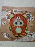 Baby Three Orange Fox enamel pin with pale belly, pink forehead accent, and gold-colored outlines on backing card