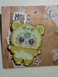 Baby Three Tan Bear enamel pin with pale belly, blue forehead accent, and gold-colored outlines on backing card