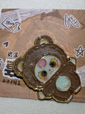 Baby Three Brown Bear enamel pin with pale belly, pink forehead accent, and gold-colored outlines on backing card